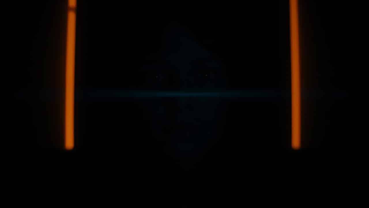 Pessoa em sala escura imersa em filme de terror com luz bruxuleante da tela.