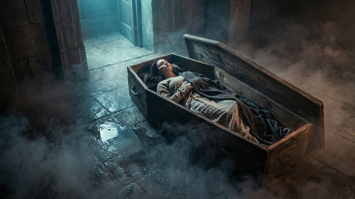 Woman sleeping in wooden coffin with mist, representing death dream meaning and psychological rebirth